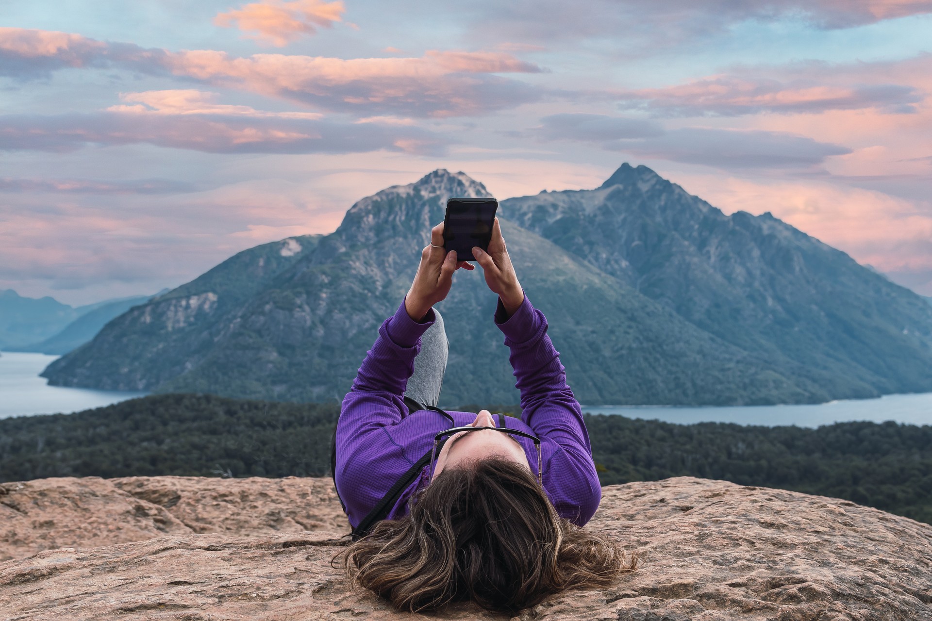 woman checking mobile, relaxed in mountainous forest